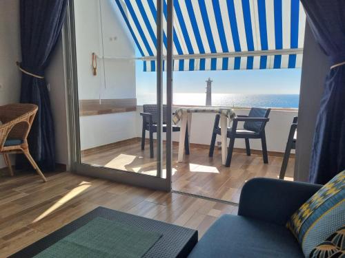 Sala de estar con mesa y vistas al océano en apartamentos Vv casafaromar en Morro del Jable