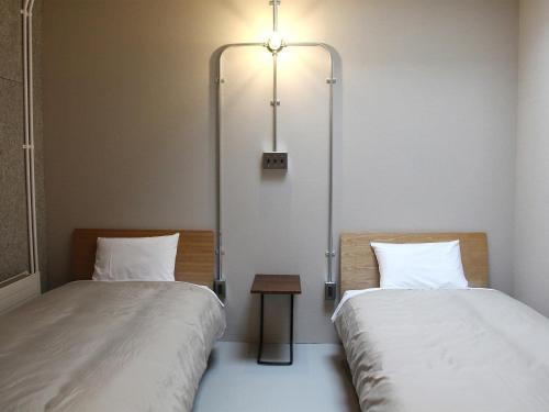 dos camas sentadas una al lado de la otra en una habitación en Guesthouse ushiyado, en Naka-shibetsu