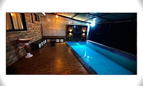 a swimming pool in a room with a table at Mount bungalows-Mount cottage-wifi-pvt pool in Lonavala