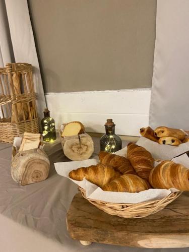 a basket of bread sitting on a table with bottles at Le Rabuons in Saint-Étienne-de-Tinée