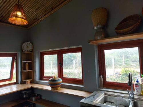 a kitchen with three windows and a sink at Mộc Châu Peachy Garden in An Pon