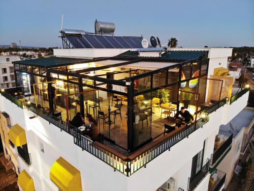 a balcony of a building with people sitting on it at Limon Inn Hotel, Taşucu in Tasucu