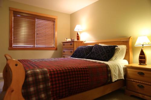 een slaapkamer met een bed, 2 lampen en een raam bij Apartment 405 Bear Creek Crossing in Canmore