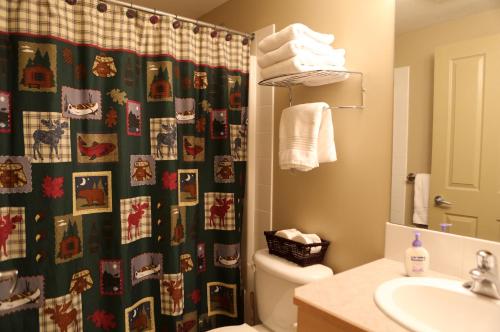 een badkamer met een kerstdouchegordijn en een toilet bij Apartment 405 Bear Creek Crossing in Canmore