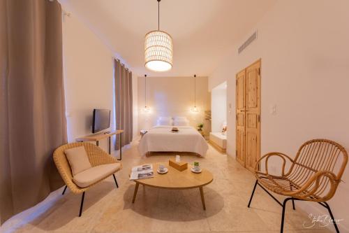 a hotel room with a bed and a table and chairs at Moulin de la Roque in Althen-des-Paluds