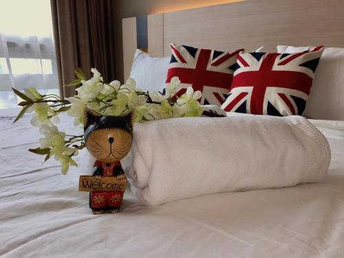a teddy bear sitting on a bed with a welcome sign at Deluxe Swiss Garden Residences Bukit Bintang City Center in Kuala Lumpur