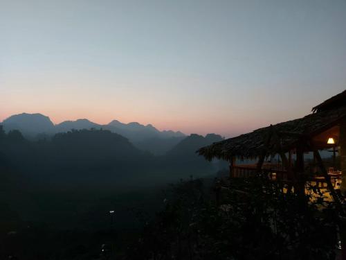 a view of the mountains at sunset with a hut at Mộc Châu Peachy Garden in An Pon