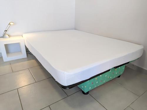 Posto letto in camera con materasso bianco di Appartement cosy avec parking proche port et plage a Cap d'Agde