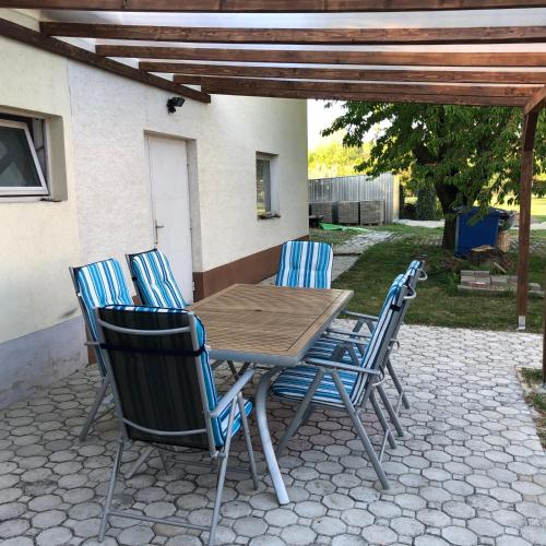 a wooden table and chairs on a patio at Elvira Vendégház in Kisbodak