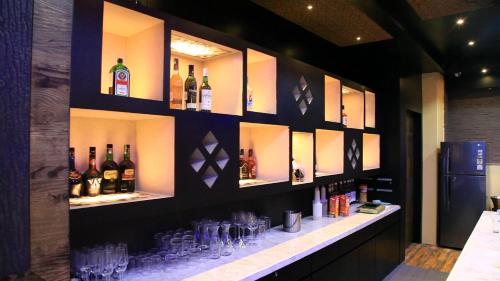 um bar com garrafas e copos na parede em HOTEL HEIGA vns em Shillong