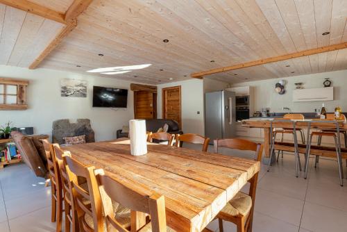 une cuisine et une salle à manger avec une table et des chaises en bois dans l'établissement Les Picaillons - Le Chalet, à Les Villards-sur-Thônes