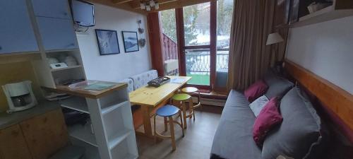 un salon avec un canapé, une table et un bureau dans l'établissement Duplex Le Vogel, à Arc 1800