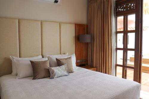 a bedroom with a large white bed with pillows at Matisia Hotel Boutique in Guaduas