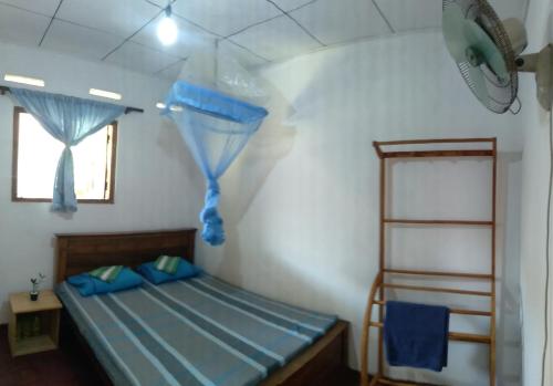 a bedroom with a bed with blue sheets and a window at Sanithu Homestay and villa Galle in Galle