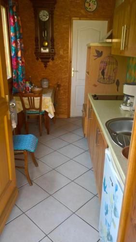 una pequeña cocina con fregadero y mesa en appartement meublé, en Vizille
