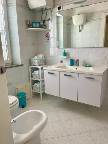 a bathroom with a sink and a toilet and a mirror at B&B Mare Monti Miniere in Iglesias