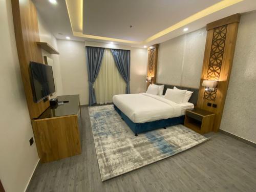 a hotel room with a bed and a flat screen tv at PRIMOTEL Elite As Salamah in Jeddah