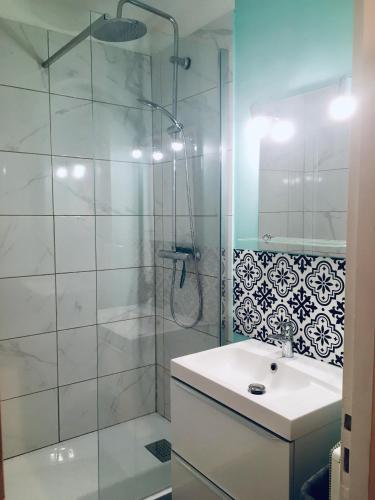 une salle de bain avec une douche et un lavabo et une cabine de douche en verre dans l'établissement Agréable studio neuf avec vue + parking gratuit, à Luchon