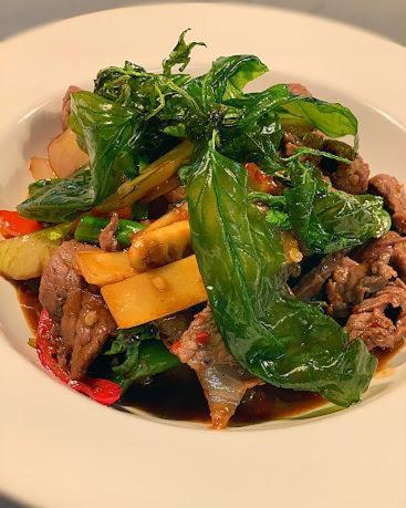 a white plate of food with meat and vegetables at Siam cottage guesthouse over 300 years old with Thai restaurant in Moreton in Marsh
