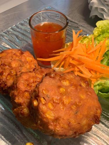 a plate of food with meat and carrots and a drink at Siam cottage guesthouse over 300 years old with Thai restaurant in Moreton in Marsh