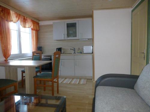 kuchnia i salon z kanapą i stołem w obiekcie Gästehaus Binder w mieście Obertraun