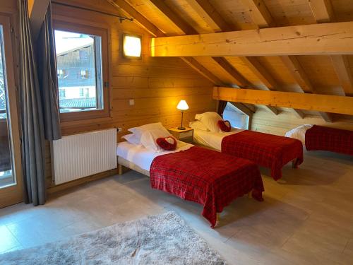 een slaapkamer met 2 bedden in een houten hut bij Bed and Breakfast Chalet Manava in Morzine