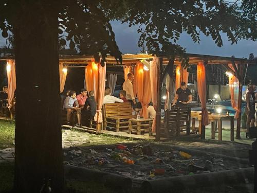 a group of people sitting in a tent at night at Brvnare Rodjak sa sela in Mionica