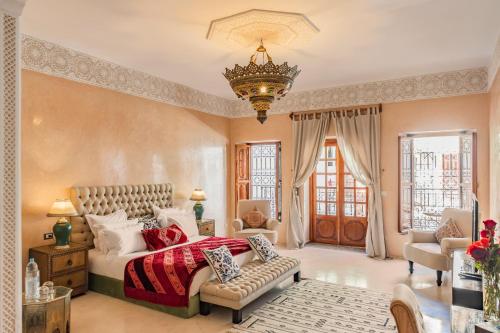 ein Schlafzimmer mit einem großen Bett und einem Kronleuchter in der Unterkunft Riad Luciano Hotel and Spa in Marrakesch