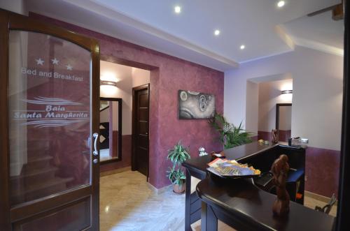 a hotel lobby with a desk and a door at Baia Santa Margherita B&B in Castelluzzo