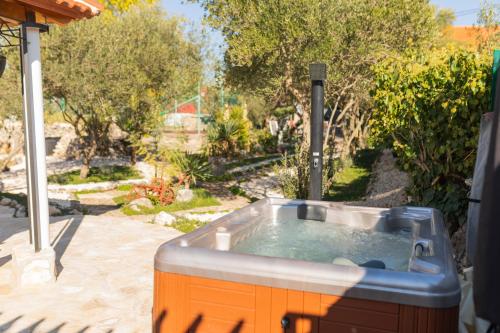 a hot tub in a backyard with a garden at Anica&Jaglica in Brištane
