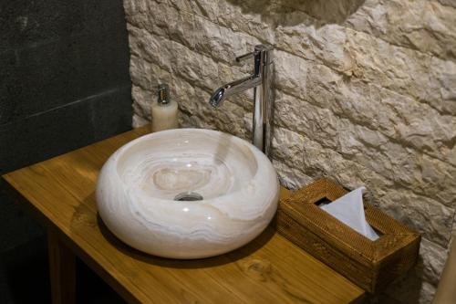 a white sink on a wooden counter in a bathroom at The Lava Bali Villa and Hot Spring in Kintamani