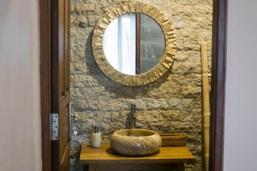 baño con lavabo y espejo en la pared en The Lava Bali Villa and Hot Spring, en Kintamani