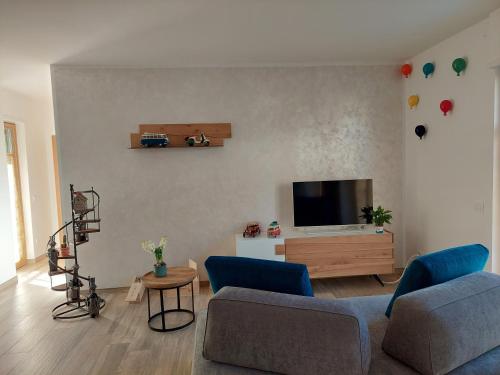 a living room with a couch and a tv at La bougainville - luxury apartment in Nago-Torbole