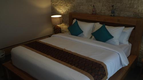 a bedroom with a large bed with green and white pillows at The Lava Bali Villa and Hot Spring in Kintamani