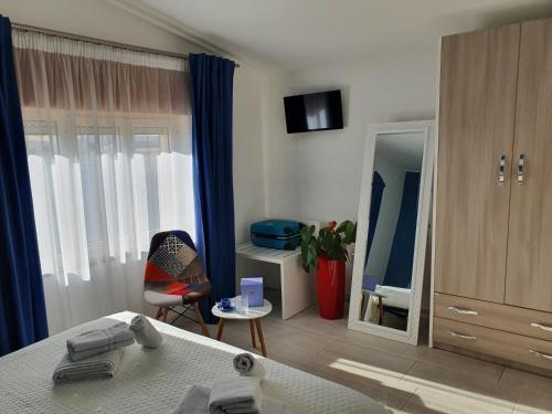 une chambre avec un lit, une chaise et un miroir dans l'établissement Blue Velvet Rooms, à Tortolì
