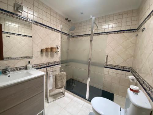 een badkamer met een douche, een toilet en een wastafel bij Casa Ana in Sanlúcar de Barrameda