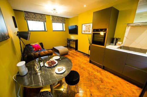 a small living room with a table and a kitchen at Luxury Travel Emporium LS1 - Luxury City Centre Apartments in Leeds