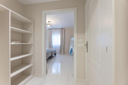 a hallway with a room with a bed and a closet at Residencia Deportiva RozaRossa in Estepona