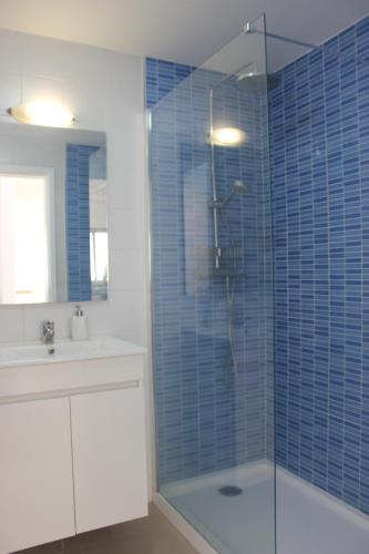 a bathroom with a shower with blue tiles on the wall at D Apartment - your home with breathtaking Views in Funchal