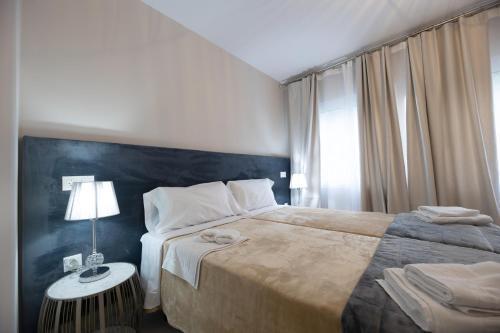 a bedroom with a large bed and a table with a lamp at Residencia Deportiva RozaRossa in Estepona