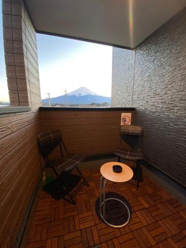 a room with two chairs and a table and a window at SAKURA FUJI in Fujikawaguchiko