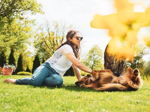 a woman playing with her dog in the grass at FAVAI HILLS your secret hideaway in Brenzone sul Garda