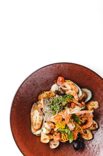 a brown plate of food with shrimp and vegetables at m3Hotel in Sankt Anton am Arlberg