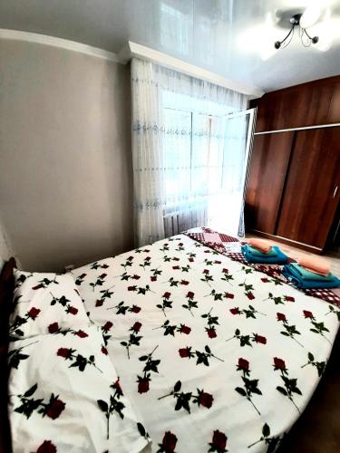 a bedroom with a bed with flowers on it at Центр города. in Almaty