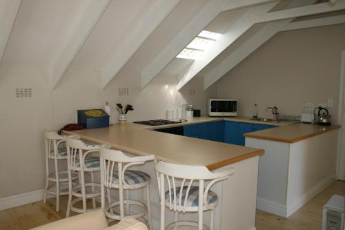 a kitchen with blue cabinets and a counter with stools at Constantia cottage- Warblers Nest in Cape Town