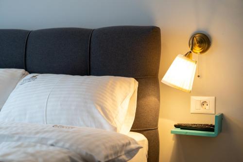 a bed with a headboard next to a lamp and a keyboard at Titova Vila Apartman Jelka in Palisad