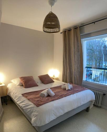 une chambre avec un grand lit avec deux serviettes dessus dans l'établissement LE LYS D'OR - cosy et proche lac, balcon terrasse, à Annecy