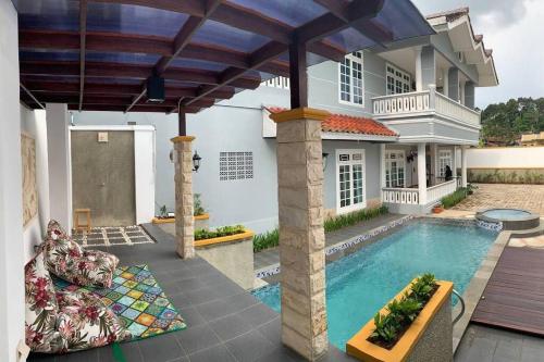 uma casa com piscina em frente a uma casa em Villa Rusa (Best Place you can get in da' town!) em Parungkuda