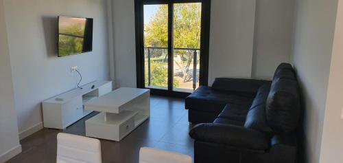 sala de estar con sofá negro y mesa en JOSE APARTAMENTo, en San José de La Rinconada