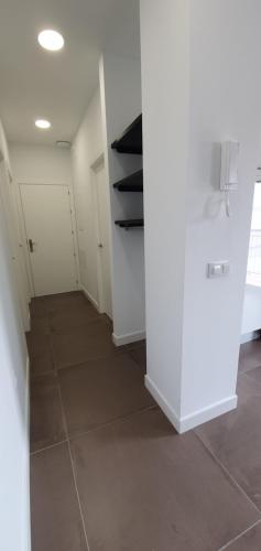 a hallway with white cabinets and a tile floor at JOSE APARTAMENTo in San Jose de la Rinconada